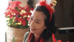Senior smiling with holiday decor.