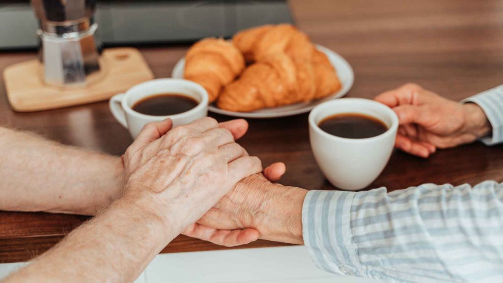 Image of people holding hands with coffee.