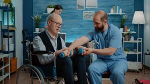 Clinician helping a disabled person with weights.