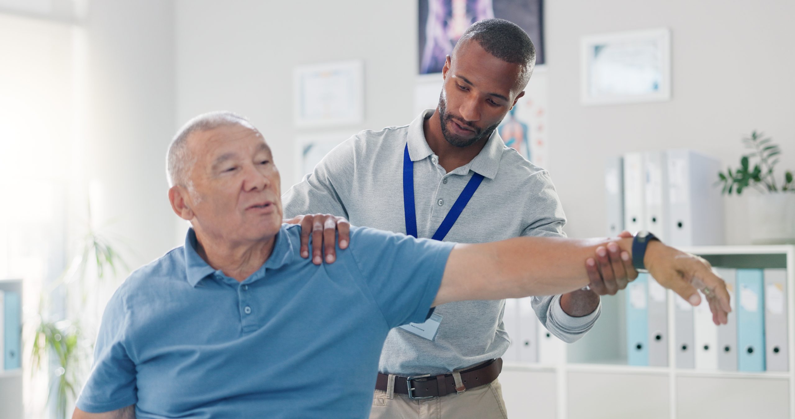 Clinician evaluating an older man's arm during an upper-extremity assessment