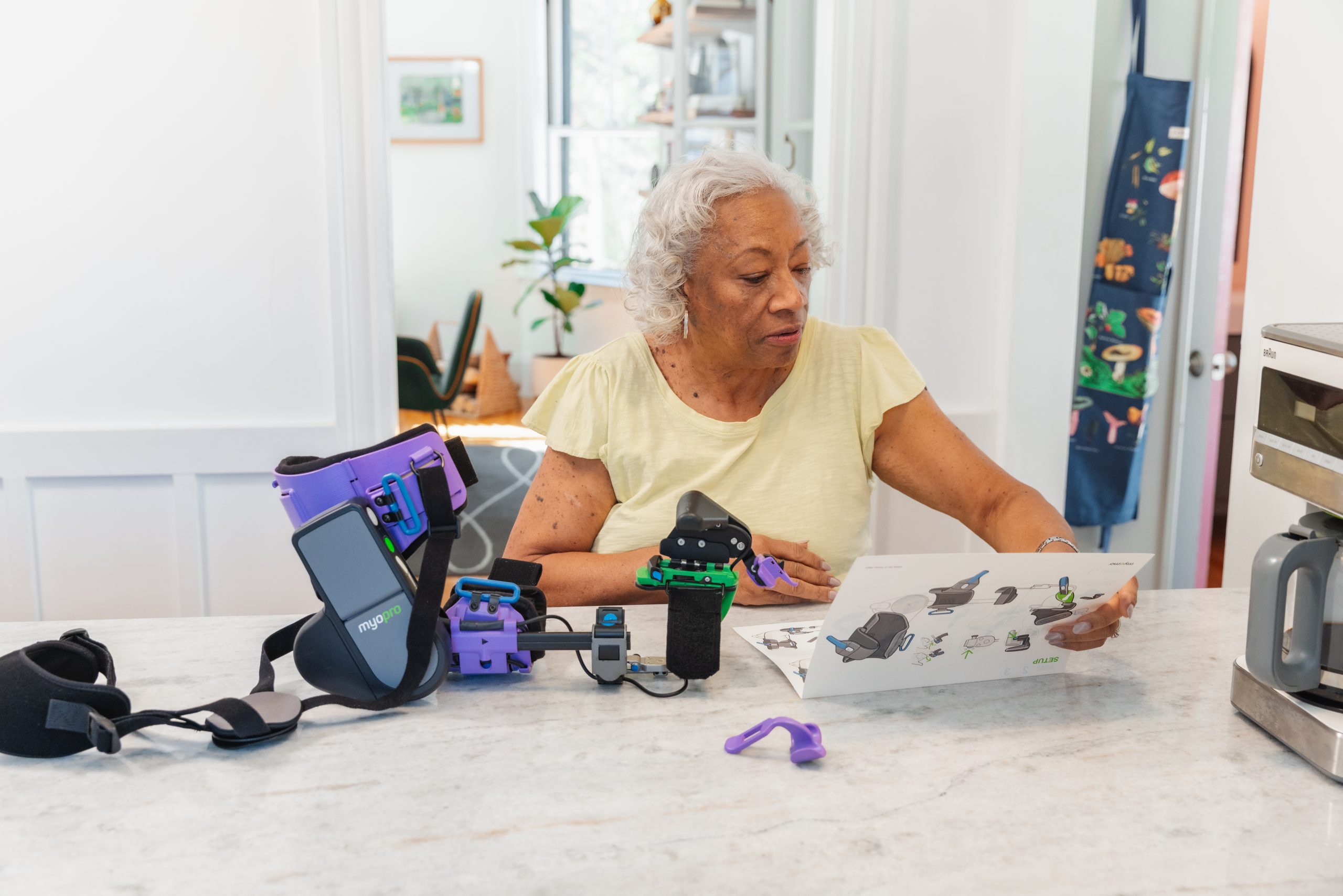 Woman reviewing instructions while putting on a MyoPro&reg;